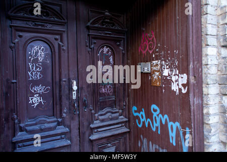 Alten roten Holztür mit hellen abstrakte Inschriften und Graffiti. Stockfoto