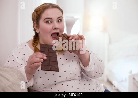 Junge Frau mit Milch Schokolade fasziniert Stockfoto