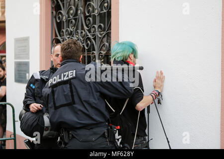 Mainz, Deutschland. 23 Apr, 2018. Ein Polizist hält einen Zähler - demonstrant gegen eine Wand. Rund 50 Rechtsextreme Demonstranten in der Innenstadt von Mainz sammelte, gegen die deutsche Regierung zu protestieren, für die Schließung der Grenzen und gegen Flüchtlinge unter dem Motto goÕ ÔMerkel hat. Sie waren gehechelt, um rund 350 Zähler - Demonstranten. Quelle: Michael Debets/Pacific Press/Alamy leben Nachrichten Stockfoto