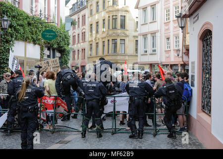 Mainz, Deutschland. 23 Apr, 2018. Polizisten Sprung über den Zaun in Richtung der Demonstranten zu hetzen. Rund 50 Rechtsextreme Demonstranten sammelten sich in der Innenstadt von Mainz, gegen die deutsche Regierung zu protestieren, für die Schließung der Grenzen und gegen Flüchtlinge unter dem Motto 'MErkel hat zu gehen'. Sie waren gehechelt, um rund 350 Zähler - Demonstranten. Quelle: Michael Debets/Pacific Press/Alamy leben Nachrichten Stockfoto