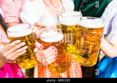 Anstoßen mit einem Bier in der Bayerischen Biergarten Stockfoto