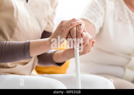 Frau beruhigend, einen Blinden, ältere Dame, die einen Stock Stockfoto
