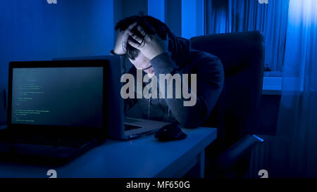 Verärgert und junge Programmierer arbeiten am Laptop zu spät abends müde Stockfoto
