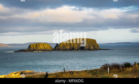 Ballintoy, Republik Irland, Großbritannien - 28/12/2016: Ein paar Touristen fotografieren der Sheep Island in der Nähe von Giant's Causeway, Nordirland Stockfoto