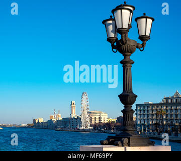 Bari, Italien - 8 April 2018: im Vordergrund die charakteristischen Lamp Post und im Hintergrund das Riesenrad montiert an der Küste Stockfoto