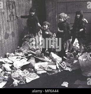 1972, historische Bild Kinder zusammen auf einem Haufen Hausmüll außerhalb, wo sie leben und spielen im Süden Londons. Der Junge ist gerade gestresst und unzufrieden. In den 1970er Jahren verbreiteten öffentlichen Sektor Arbeiter Streiks wurden ein gemeinsames Merkmal des britischen Lebens und weigern sich, war eines der Dinge, die nicht für die Wochen, die zu ernsten Umwelt und Fragen der öffentlichen Gesundheit gesammelt und für Kinder Gefahr beim Spielen im Freien. Stockfoto