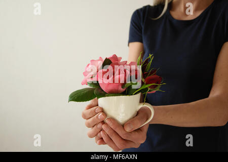 Vorderansicht des junge Frau hält eine Schale mit schönen frischen Rosen Stockfoto