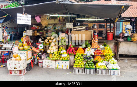 Eine weibliche Ladenbesitzer in Ihrem Obst und Markt in der Tonne, Dam Straßenmärkte, Ho Chi Minh City, Vietnam. Stockfoto