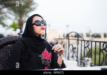 Muslimische Frau Shisha rauchen in einer Bar im Freien Stockfoto