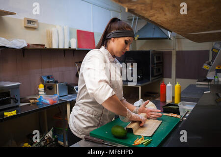 Frau in Weiß Küchenchef bereitet Sushi Restaurant. Stockfoto