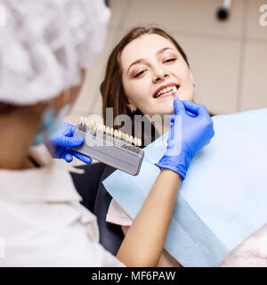 Des Patienten Zähne Schatten mit Proben für die Behandlung bleichen. Stockfoto