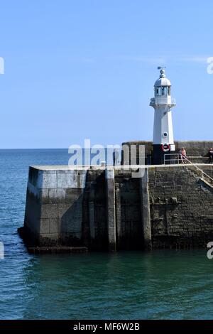 Ufermauer mit Licht Haus in Mevagissey Hafen in Cornwall. Stockfoto