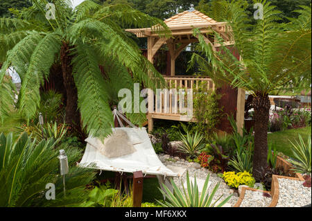 Exotische Palmen, Pavillon, Hängematte, Pfad und Blumen im tropischen Stil zeigen Garten - Besuch der Plantage: Koloniale Chic und Bajan Wurzeln. RHS zeigen Tatton Park. Stockfoto