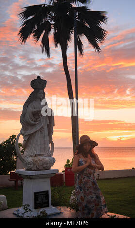 Asiatische Frau touristische beten mit Maria Statue an merizo Glockenturm in Guam Stockfoto