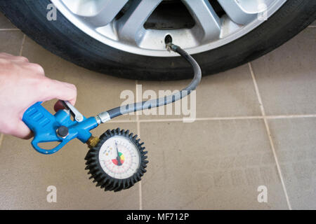 Nahaufnahme der Hand Holding Manometer zur Druckmessung Auto Reifen Stockfoto