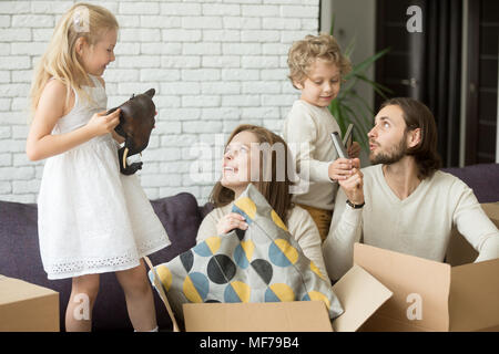 Glückliche Kinder Eltern helfen Boxen am Umzugstag zu entpacken Stockfoto