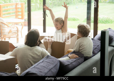 Tochter Sprung aus Karton aufgeregt, Familie spielen Pack Stockfoto