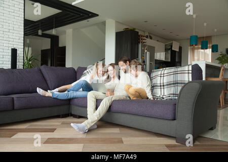 Eltern mit Kindern Spaß mit Laptop im Wohnzimmer Stockfoto