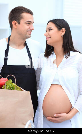 Mann und seine schwangere Frau sind Kämmen durch die Pack, stehen in der Küche Stockfoto