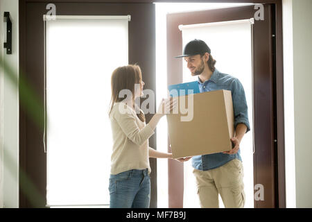 Lächelnd Kurier Paket liefern an junge Frau, Lieferung Servi Stockfoto