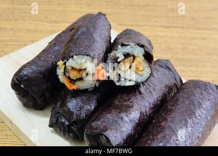 Japanische Küche, Traditionelle Vagetarian Japanischen Reis Maki Sushi Roll Material mit Tofu und Karotte eingewickelt in Nori Algen. Stockfoto