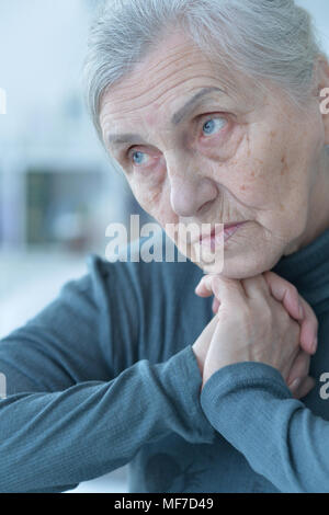 Close up Portrait von traurige ältere Frau am Tisch sitzen Stockfoto