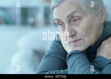 Close up Portrait von traurige ältere Frau am Tisch sitzen Stockfoto