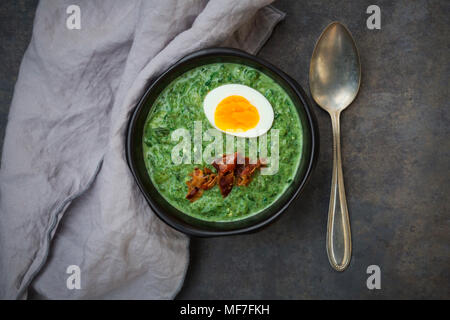 Creme von spinatsuppe mit Ei und Speck Stockfoto