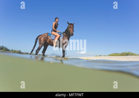 Indonesien, Bali, Frau sitzt auf Pferd Stockfoto