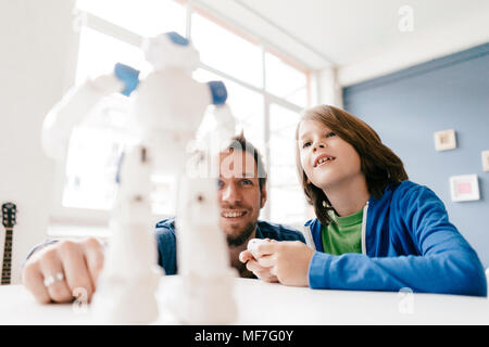 Vater und Sohn am Roboter auf der Suche auf dem Tisch zu Hause Stockfoto
