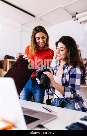 Zwei Fashion Designer mit Kamera und Laptop im Studio Stockfoto
