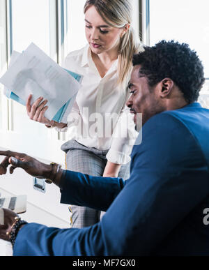 Unternehmerin und Unternehmer diskutieren Papiere Stockfoto