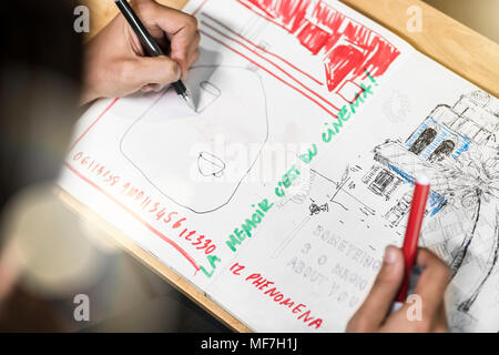Künstler sitzen im Cafe, Zeichnung in seinem Notebook Stockfoto