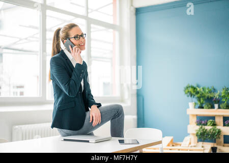 Geschäftsfrau, die von zu Hause aus arbeiten, Telefonieren Stockfoto