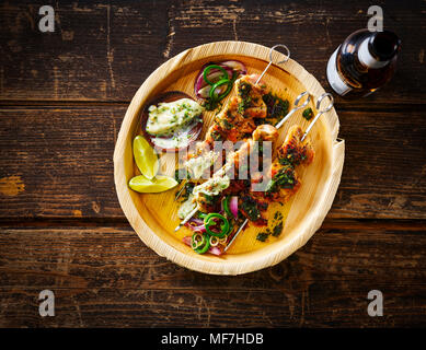 Gegrilltes Hähnchen am Spieß und Knoblauch Mayonaise auf Platte, Bier Flasche Stockfoto