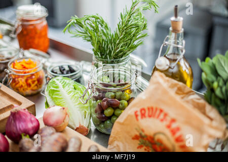 Verschiedene Zutaten, grüne Oliven im Glas Stockfoto