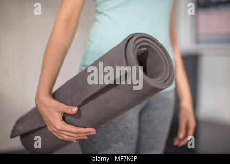 In der Nähe der Frau, die Yoga Matte im Studio Stockfoto