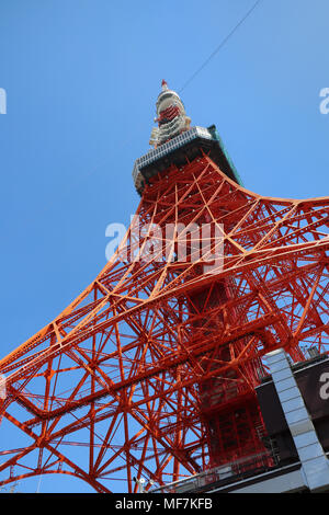 Helle international orange Tokyo Tower in Japan über den Viewer, Aufzucht bis schräg gegen einen blauen Himmel. Kopieren Sie Raum um das Wahrzeichen. Stockfoto