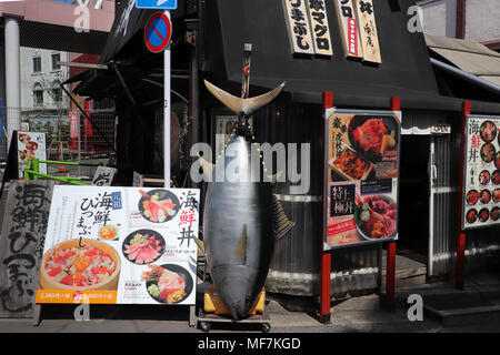 Kleine schwarze Sushi Restaurant in der Nähe des riesigen Tsukiji Fischmarkt in Tokio, Japan, eine riesige Thunfische und Bilder von Mahlzeiten, und die Speisekarte. Stockfoto