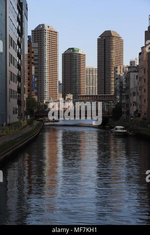 Blick hinunter vom Kamejima-gawa Fluss in Tokio, Japan, in der Nähe der Hatchobori Station. Blauer Himmel, hohe Gebäude in den Fluss in den späten Nachmittag. Stockfoto