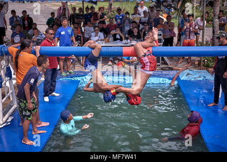 Ungewöhnlicher Sport. Muay Thai Kämpfer im Wettbewerb auf einem Battle Beam über dem Wasser thront. Thailand Südostasien Stockfoto