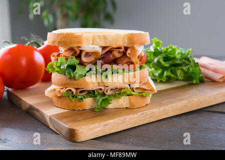 Frische Triple Decker Türkei Club Deli Sandwich auf Schneidebrett Stockfoto