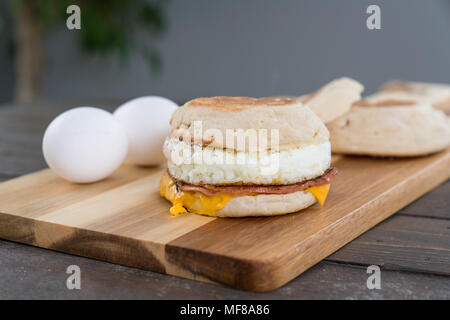 Canadian Bacon, Ei und Käse Breakfast Sandwich mit Englisch muffin auf Schneidebrett Stockfoto