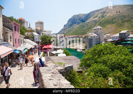 Stari Most, der Alten Brücke in Mostar, Bosnien und Herzegowina mit Touristen und Geschäfte im Vordergrund. Stockfoto