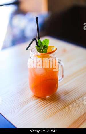 Glas Orangensaft auf hölzernen Tisch in Coffee House. Stockfoto