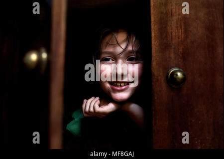 Wunderschöne 9 Jahre alte Junge spielt im Schrank. Stockfoto