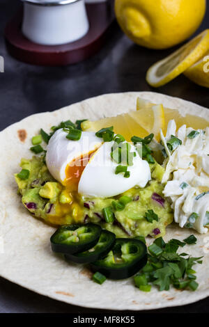 Pochierte Eier und guacamole Sauce auf Mehl Tortilla, mexikanischen Stil Frühstück Stockfoto