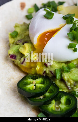 Pochierte Eier und guacamole Sauce auf Mehl Tortilla, mexikanischen Stil Frühstück Stockfoto