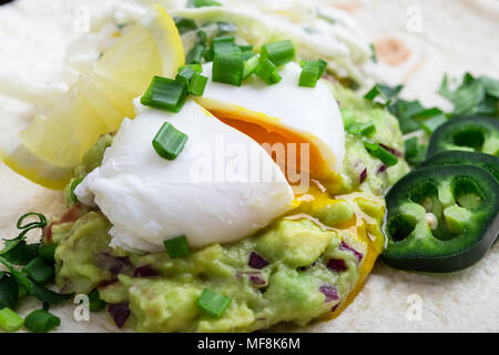 Pochierte Eier und guacamole Sauce auf Mehl Tortilla, mexikanischen Stil Frühstück Stockfoto