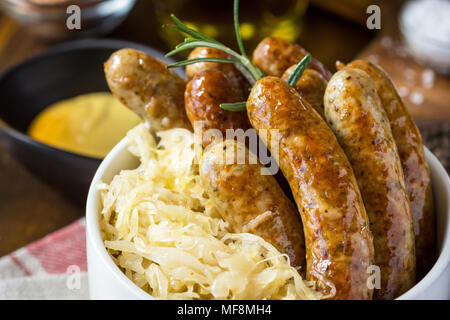 Traditionelle deutsche Würstchen mit Krautsalat, Senf und Bier. Bratwurst und Sauerkraut. Stockfoto